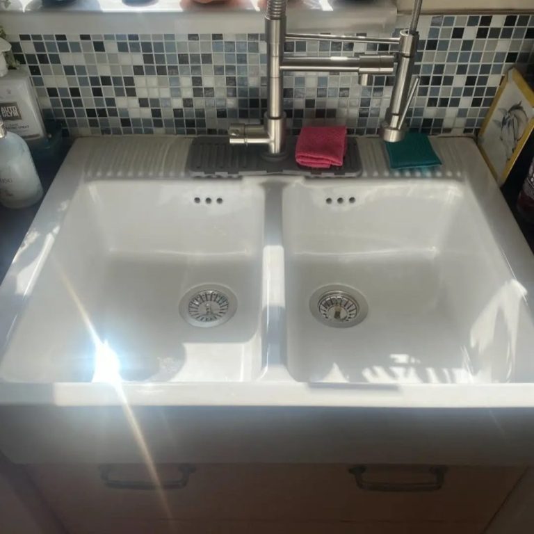 Sparkling Clean Sink Double kitchen sink with a modern tap, set against a tiled backsplash.