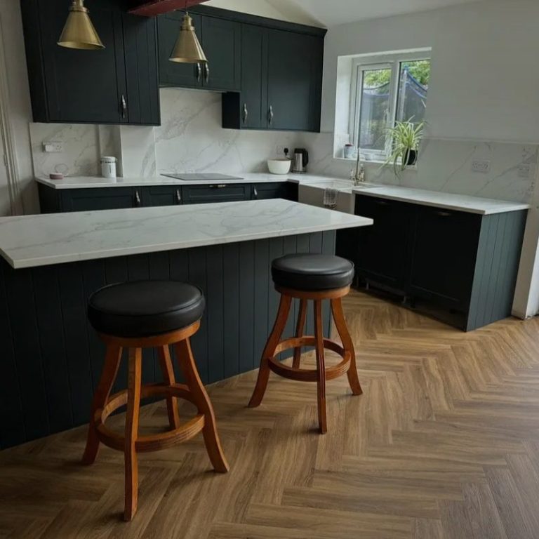 Clean Kitchen Modern Clean Kitchen with dark cabinets, marble counter tops, and wooden bar stools.