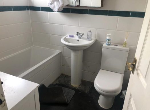 Small bathroom featuring a bathtub, sink, and toilet.