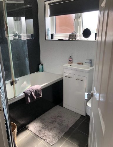 Modern bathroom featuring a bathtub, shower, sink unit, and grey floor tiles.